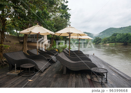 Relax seats by river in morning with mist in Kanchanaburi 96399668