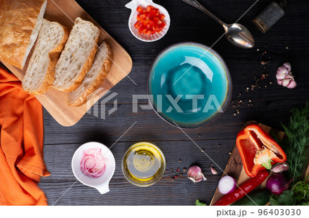fresh ciabatta bread  with blue bowl and ingredients served at dark wooden table. meditarranean cuisine. flat lay 96403030