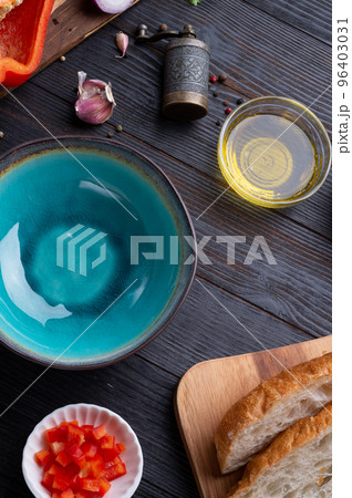 fresh ciabatta bread  with blue bowl and ingredients served at dark wooden table. meditarranean cuisine. flat lay 96403031