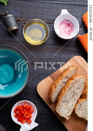 fresh ciabatta bread  with blue bowl and ingredients served at dark wooden table. meditarranean cuisine. flat lay 96403032