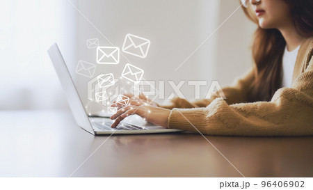 Woman using computer laptop and sending online message with email icon 96406902