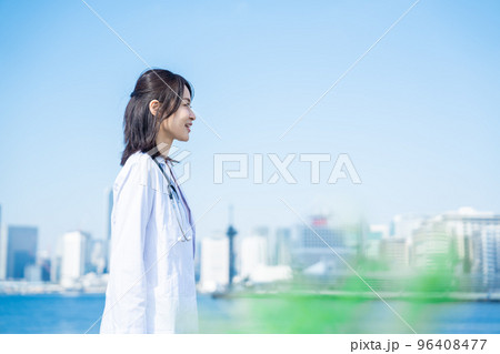 笑顔で外を歩く女性のドクター 96408477