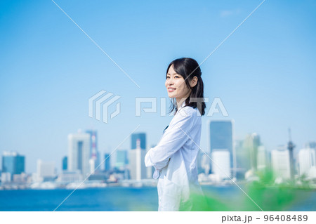 笑顔で外を歩く女性のドクター 96408489