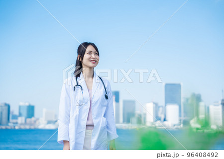 笑顔で外を歩く女性のドクター 96408492