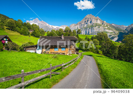 Narrow mountain road and small house on the green field Narrow mountain road and small house on the green field 96409038