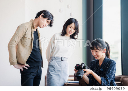 カメラを持って話す若い女性 96409039