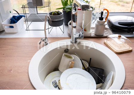 Dirty dishes in the sink in the kitchen, mess after lunch, too lazy to wash dishes. Kitchen cleaning, detergent, cleaning services Dirty dishes in the sink in the kitchen, mess after lunch, too lazy to wash dishes. Kitchen cleaning, detergent, cleaning services 96410079