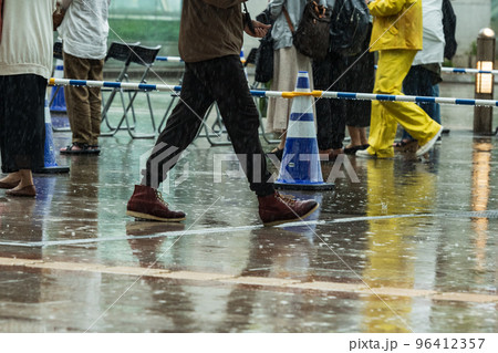 雨の街を足早に歩く人 96412357