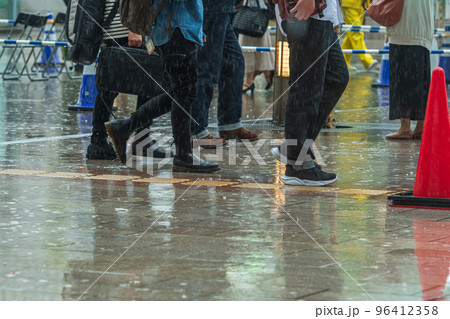 雨の街を足早に歩く人 96412358