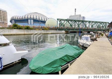 京セラドーム大阪をバックに尻無川のワーレントラス橋を渡るJR西日本323系電車 96416026