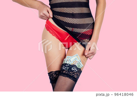 Closeup of a sexy woman body in red panties and black sexy transparent dress touching herself dollar bills tucked in her stockings on pink background in the studio. intimate massage sex games Closeup of a sexy woman body in red panties and black sexy transparent dress touching herself dollar bills tucked in her stockings on pink background in the studio. intimate massage sex games 96418046