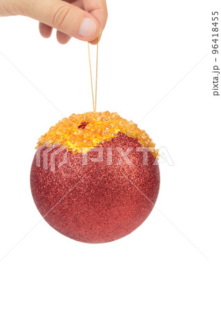 Hand holds a red christmas ball.  96418455