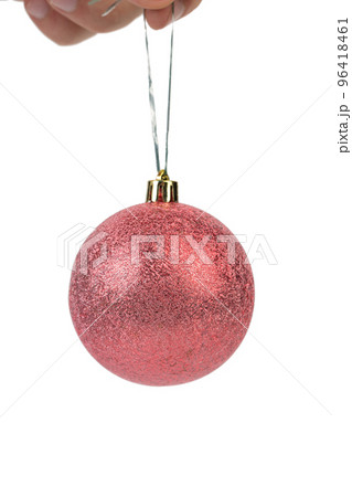 Hand holds a red christmas ball. 96418461