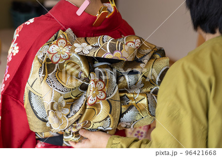 若い女性に振袖の着付けしているところ 若い女性に振袖の着付けしているところ 96421668
