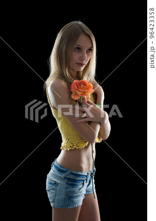 Young pretty woman with flower over black 96423358