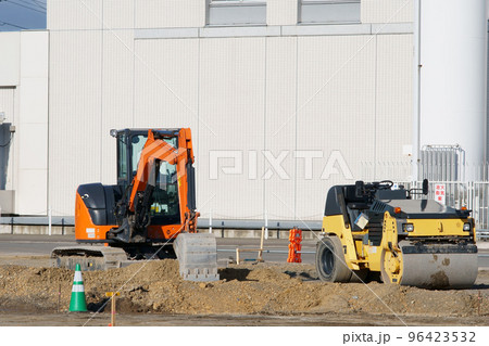 建設現場の振動ローラーとショベルカー 96423532