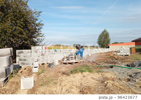 Construction of a fence on a private territory, a worker while performing work. 96423677