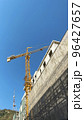 Tower building crane against the blue sky and sun. Construction of new buildings with a crane. Tower crane in Tbilisi, Georgia 96427657