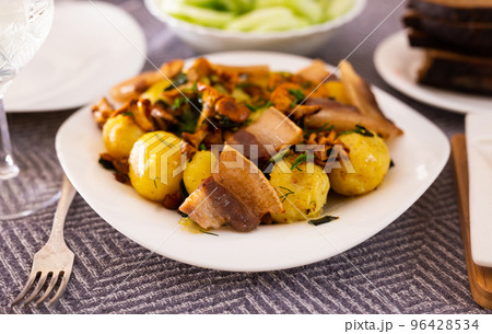traditional rustic dish. fried potatoes with chanterelle mushrooms and pork brisket with herbs traditional rustic dish. fried potatoes with chanterelle mushrooms and pork brisket with herbs 96428534