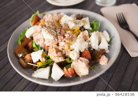 Fish salad with canned tuna and corn, tomatoes and arugula 96428536