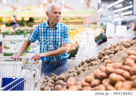 old age man choosing potato in supermarket 96428682