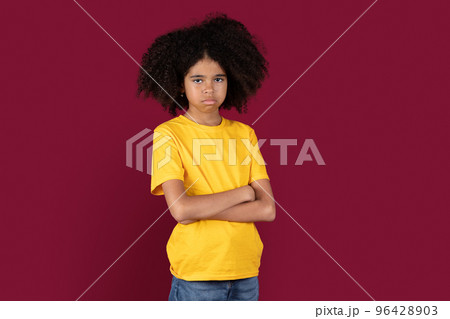 Offended black child posing over colorful studio background 96428903