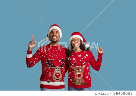 Happy black couple pointing up at copy space, xmas offer Happy black couple pointing up at copy space, xmas offer 96429035