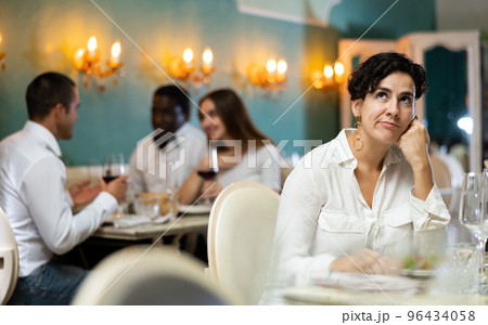 Bored woman eating dinner alone in restaurant 96434058