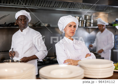 Woman head chef posing in restaurant kitchen 96434112