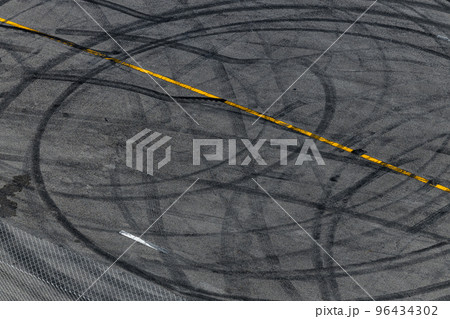 Tire track mark on asphalt tarmac road race track texture and background, Abstract background black tire tracks skid on asphalt road in racing circuit, Tire mark skid mark on asphalt road. Tire track mark on asphalt tarmac road race track texture and background, Abstract background black tire tracks skid on asphalt road in racing circuit, Tire mark skid mark on asphalt road. 96434302