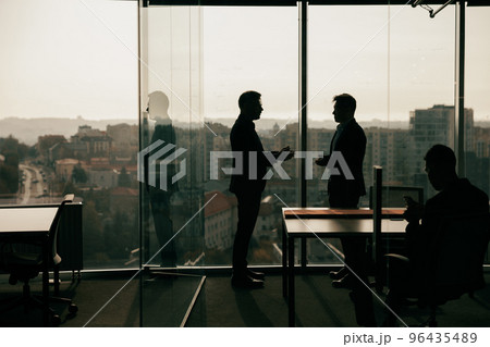 Silhouette photo of businesspeople during working day in modern meeting room 96435489
