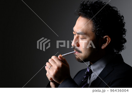 煙草を吸うダンディな男性の横顔　タバコに火をつける 96436004