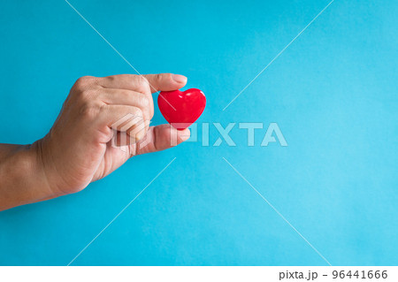 Heart health concept. Man's finger holding a red heart shape. 96441666