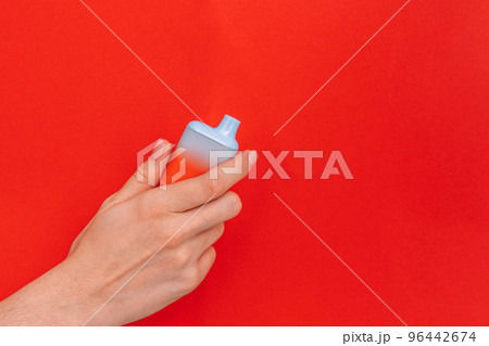 Vape in female hand against red background Vape in female hand against red background 96442674