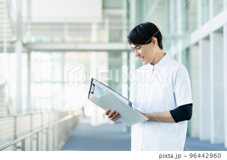 カルテを確認する若い男性看護師 96442960