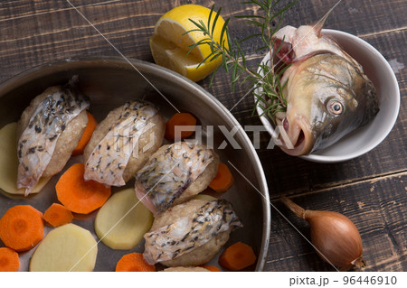 In a frying pan, fish cakes or meatballs decorated with fish skins, next to the frying pan are lemon, onion, fish In a frying pan, fish cakes or meatballs decorated with fish skins, next to the frying pan are lemon, onion, fish 96446910
