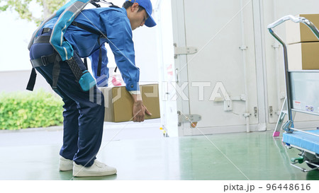 倉庫でパワーアシストスーツを使う作業員 倉庫でパワーアシストスーツを使う作業員 96448616