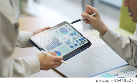 タブレット画面を見て話す人々 96448627
