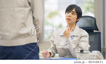 オフィスで部下と話す作業服を着た上司 オフィスで部下と話す作業服を着た上司 96448631