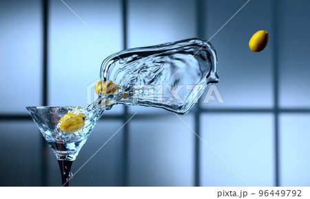 Martini and green olives in glass with splashes. 96449792