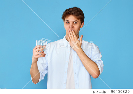 Young handsome man with drinking glass of water 96450329