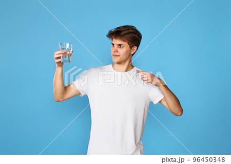Young handsome man with drinking glass of water 96450348