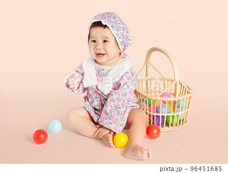 asian baby girl looking front and play toy ball. 96451685