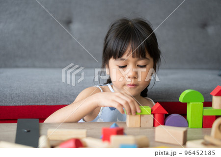 Cute Asian little girl playing with colorful toy blocks, Kids play with educational toys at kindergarten or daycare. The creative playing of the kid development concept, Toddler kid in the nursery. 96452185