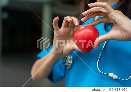 Female Cardiovascular disease doctor or cardiologist with stethoscope holding red heart, Medical health care and doctor staff service concept. Female Cardiovascular disease doctor or cardiologist with stethoscope holding red heart, Medical health care and doctor staff service concept. 96453442