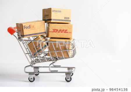 Bangkok, Thailand - September 26, 2022 Shopping cart with DHL Amazon express packing box, import export online exchange investment business. 96454136