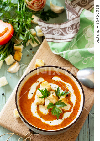 Diet menu. Puree soup tomato with croutons and cream in a bowl on a kitchen wooden table. The concept of healthy eating. Diet menu. Puree soup tomato with croutons and cream in a bowl on a kitchen wooden table. The concept of healthy eating. 96456018