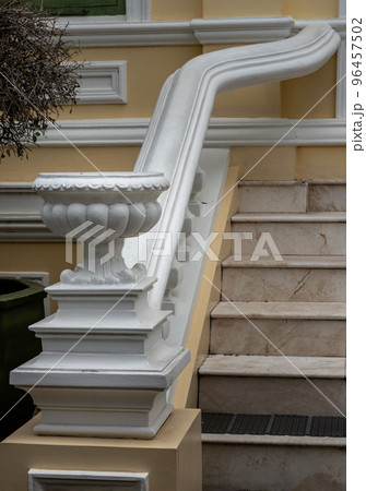 White cement vase as decoration next to the beautiful marble staircase. Roman style ornamental flowerpot, White cement vase as decoration next to the beautiful marble staircase. Roman style ornamental flowerpot, 96457502