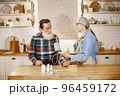 Old couple in a kitchen. Woman in a blue shirt and aprone. 96459172