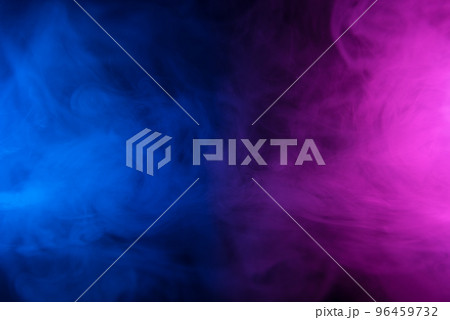 Clouds of colorful smoke in blue and purple neon light swirling on black table background  96459732